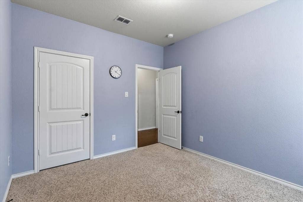 1713 Falling Star Drive, Fort Worth, TX 76052 Plush carpeting, light blue wall paint, white trim, and white paneled doors