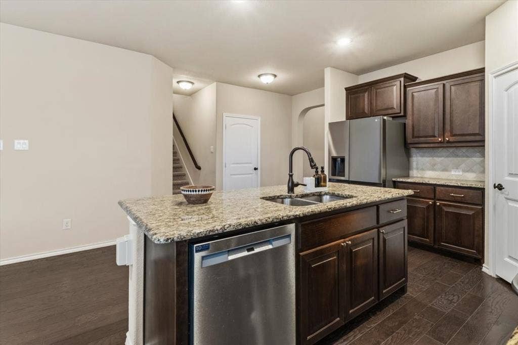 1713 Falling Star Drive, Fort Worth, TX 76052 Kitchen featuring an island with double sinks, stainless steel dishwasher, and granite countertops