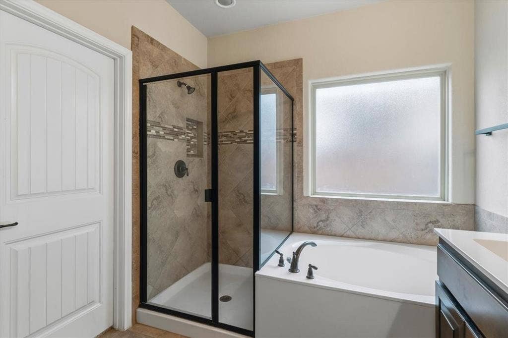 1713 Falling Star Drive, Fort Worth, TX 76052 Step-in shower with dark-framed glass enclosure, tile surround, and decorative accent band