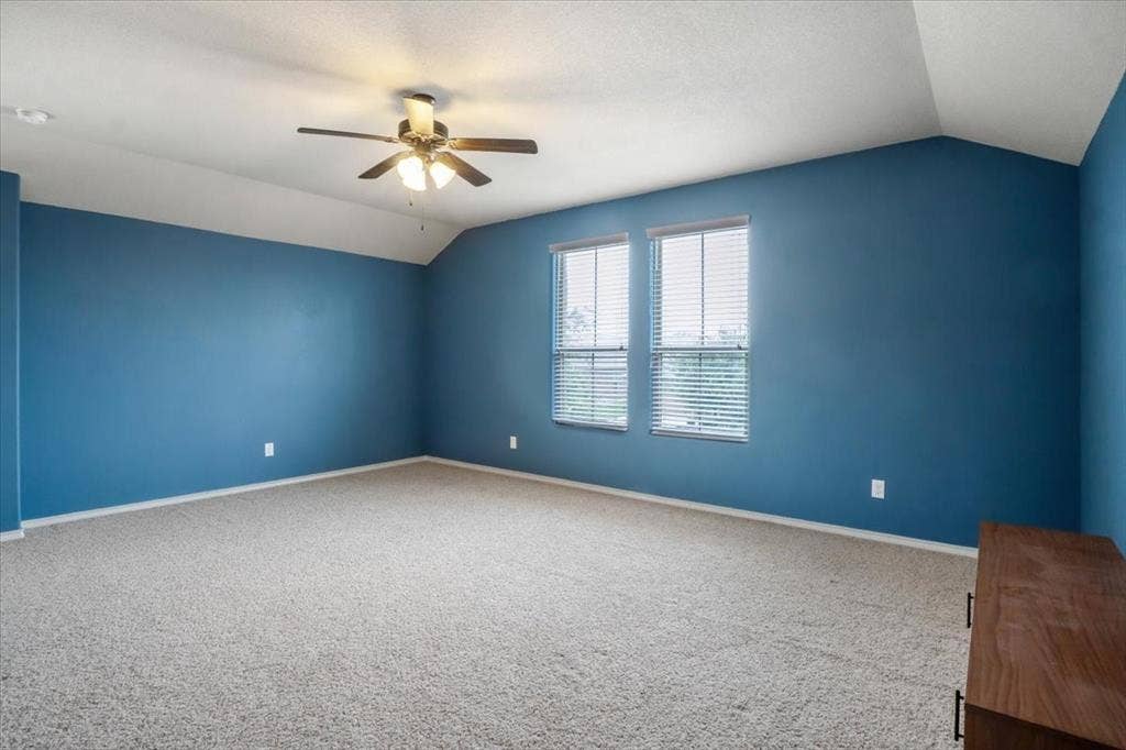 1713 Falling Star Drive, Fort Worth, TX 76052 Room featuring vaulted ceilings, dual windows with blinds, a ceiling fan with integrated lighting, and carpet flooring