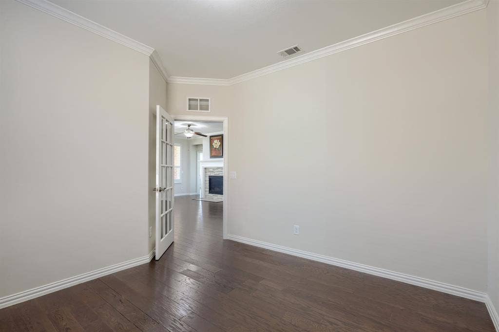 Wood-finish flooring, crown molding, and white trim accents