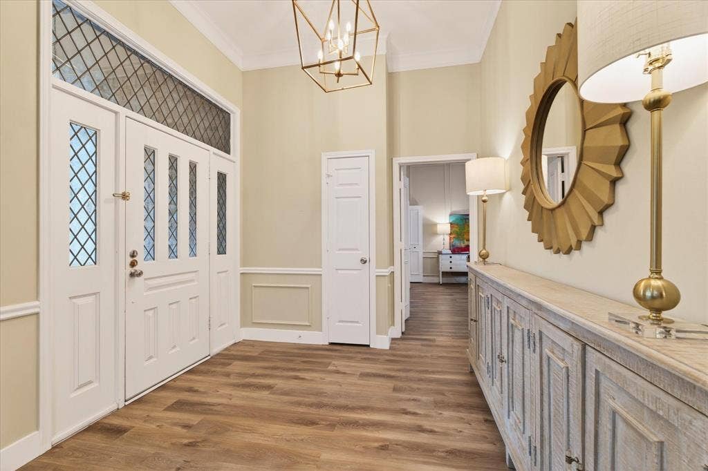 Wood-finish flooring with a decorative entry door and sidelights