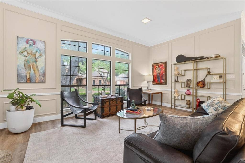 Tall windows with arched transom, wood-finish flooring, recessed lighting, crown molding, and wall paneling