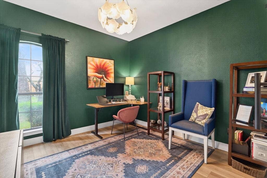 Wood-finish flooring, built-in shelving, arched window, and overhead pendant lighting