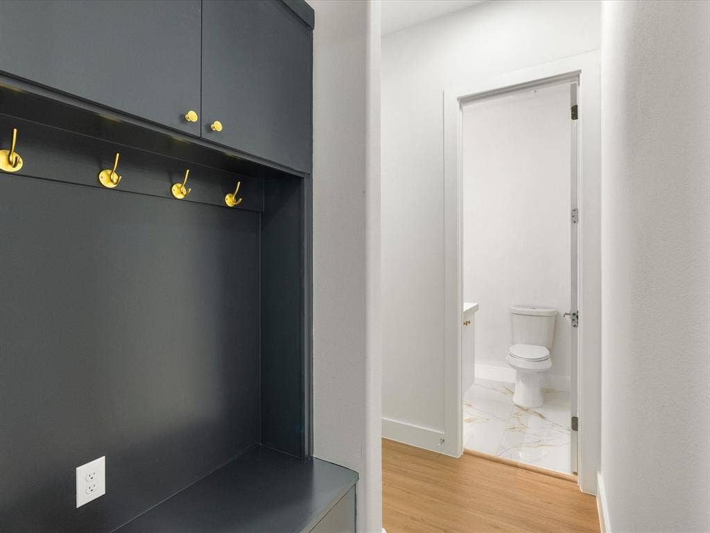 1711 Kraft Street, Dallas, TX 75212 Built-in cabinetry with gold-toned hardware, five gold-toned wall hooks, and a built-in bench