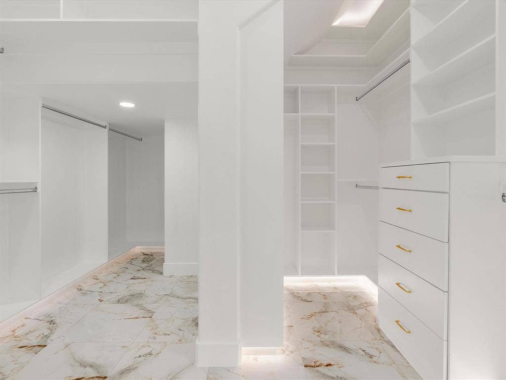 1711 Kraft Street, Dallas, TX 75212 Custom closet system featuring built-in shelving, drawers with gold-toned hardware, under led lighting and recessed ceiling lighting.