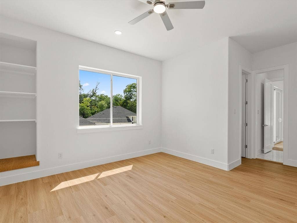 1711 Kraft Street, Dallas, TX 75212 Luxury vinyl flooring, built-in shelving, white walls, recessed lighting, and a ceiling fan.