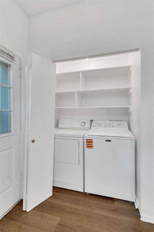 Dedicated laundry area with built-in shelving and wood-finish flooring