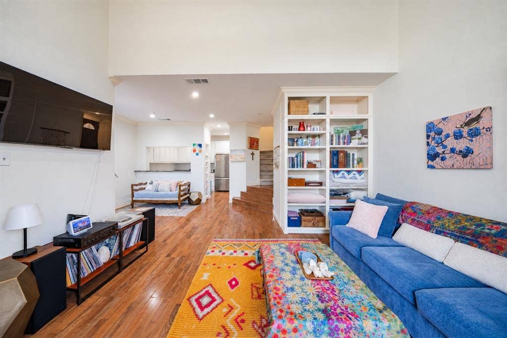 The living room features a built-in floor to ceiling shelving.