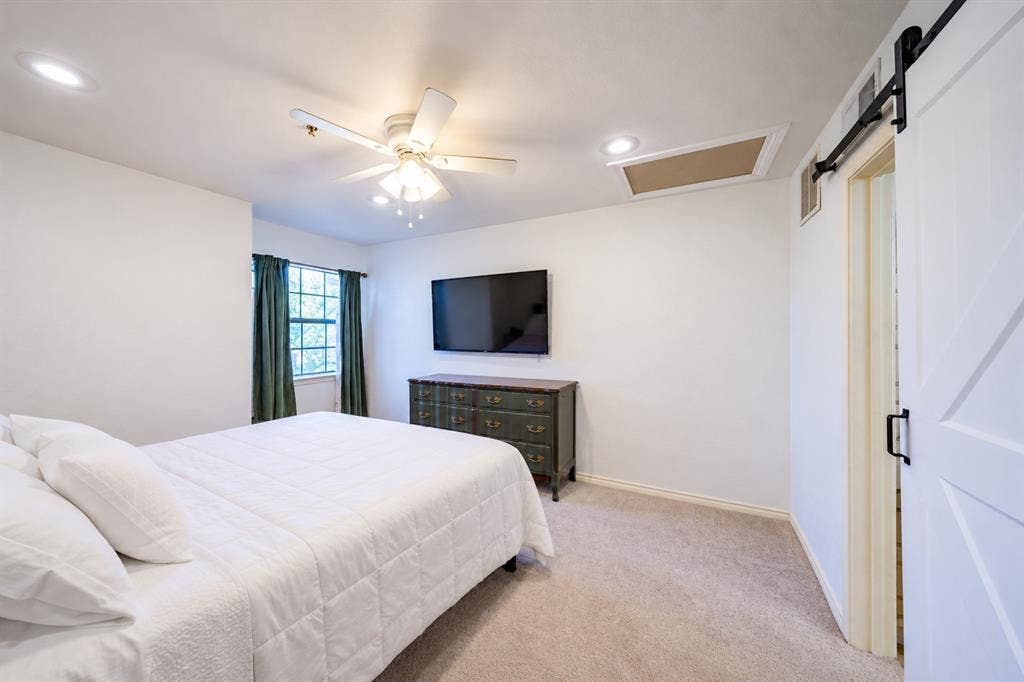 The primary bedroom is located on the second floor. The barn door to the right in the photo leads to the full bath.