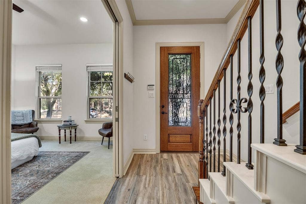 8249 Short Street, Frisco, TX 75034 Wood-finish flooring, staircase with wrought iron balusters and wood handrail, solid wood entry door with decorative glass, and recessed lighting