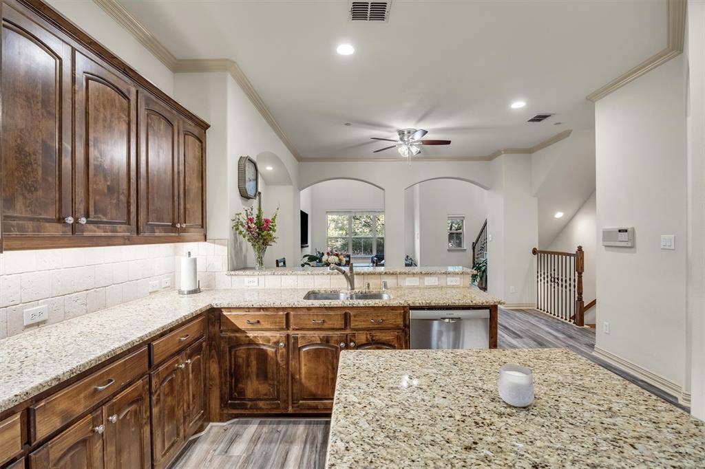 8249 Short Street, Frisco, TX 75034 Kitchen featuring wood cabinetry, light-toned countertops, a tile backsplash, recessed lighting, and stainless steel appliances