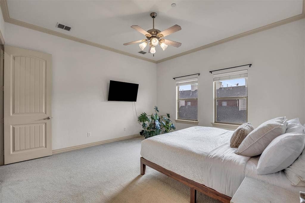 8249 Short Street, Frisco, TX 75034 Carpeted room with a ceiling fan, two windows, and crown molding