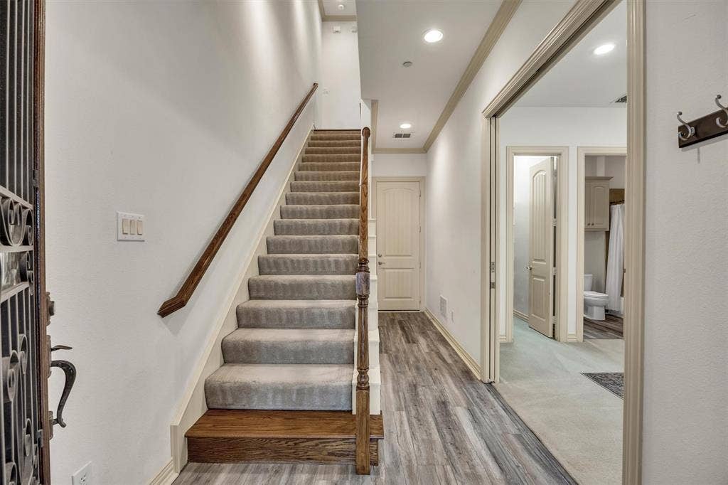 8249 Short Street, Frisco, TX 75034 Carpeted staircase with wood handrail, recessed lighting, and wood-finish flooring