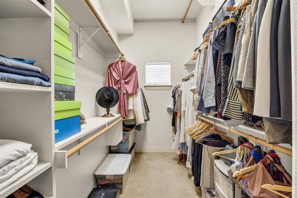 8249 Short Street, Frisco, TX 75034 Walk-in closet featuring built-in shelving, multiple hanging rods, and a window with blinds