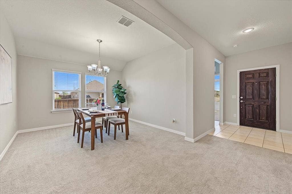 Dining area with carpet flooring, recessed lighting, and a multi-light chandelier