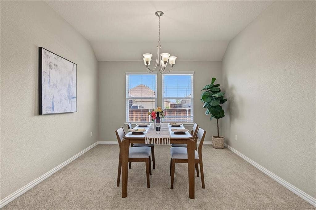Tray ceiling with chandelier, textured walls, carpet flooring, and window blinds