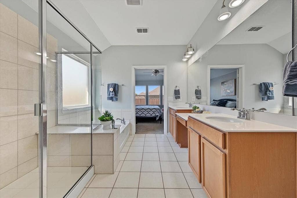 Dual vanities with integrated sinks, ample storage cabinetry, and a full-width mirror
