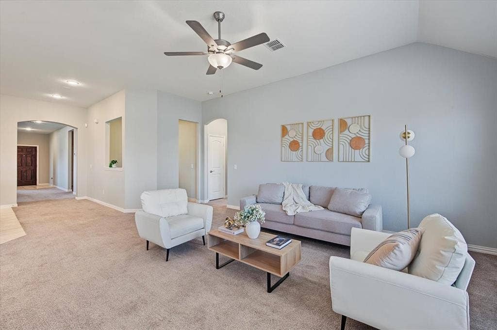 Vaulted ceiling with a ceiling fan, arched doorways, light-colored carpeting, and recessed lighting