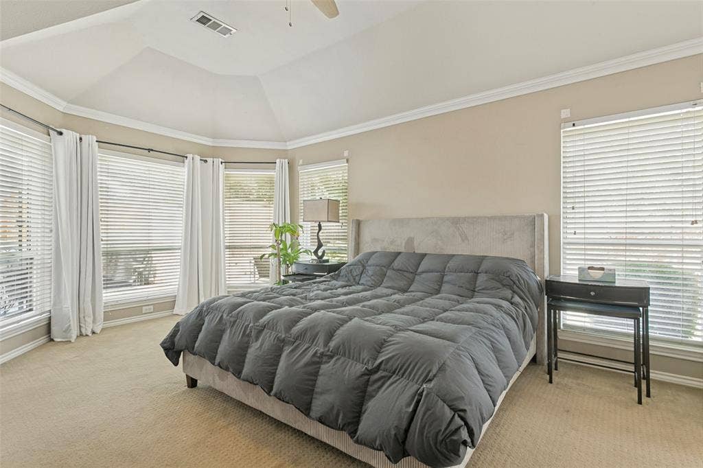 Vaulted ceiling with crown molding, carpet flooring, multiple windows with blinds, and recessed lighting