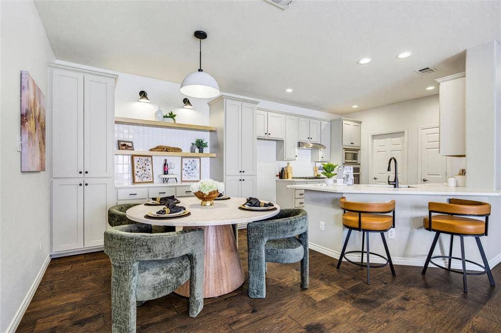 10138 Planters Row Drive, Frisco, TX 75033 The renovated kitchen's breakfast bar pulls up stools for morning coffee, casual meals, or appetizers while dinner comes together.