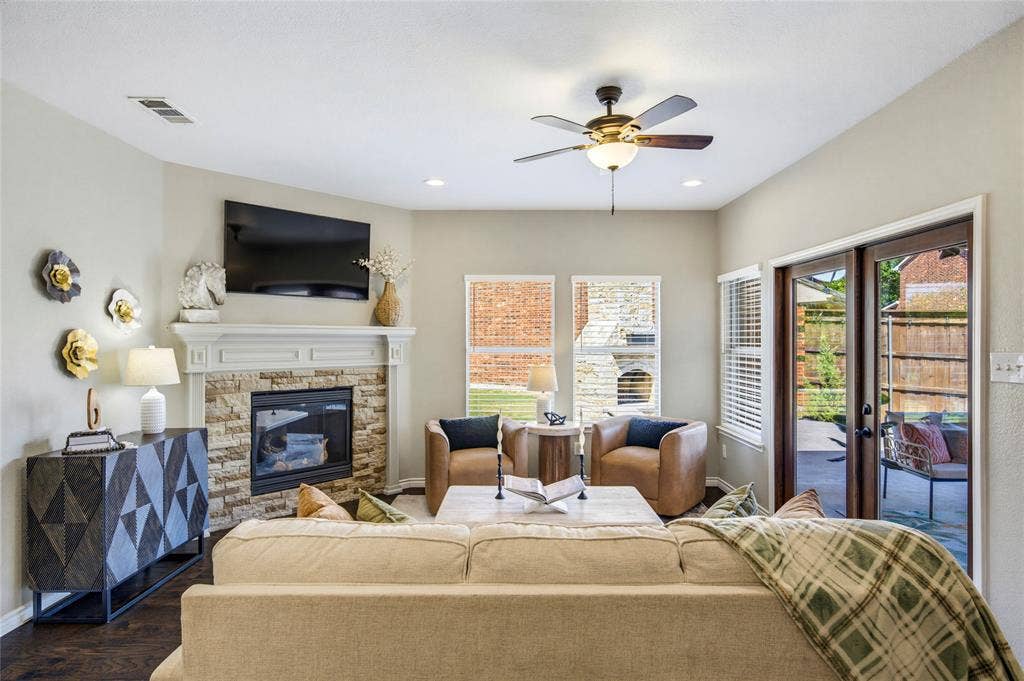 10138 Planters Row Drive, Frisco, TX 75033 Large windows overlook the backyard, connecting the living room to the outdoor living spaces just beyond.