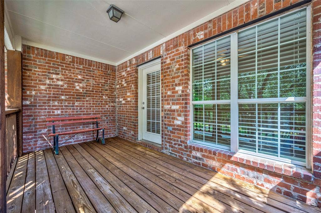 10138 Planters Row Drive, Frisco, TX 75033 Brick walls, wood decking, and a covered ceiling create a cozy outdoor retreat right off the upstairs bedroom.