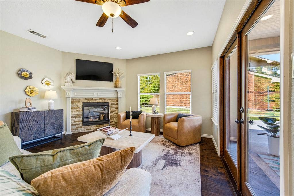 10138 Planters Row Drive, Frisco, TX 75033 A switch-on gas fireplace anchors the room while a wall of windows keeps it bright. And yes, the framed TV conveys.