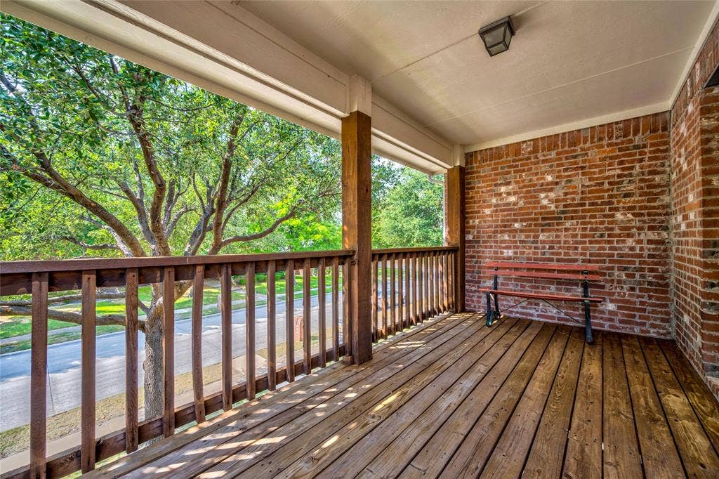 10138 Planters Row Drive, Frisco, TX 75033 A covered balcony with wood decking and treetop views, giving you a front-row seat for west-facing sunsets or morning coffee.