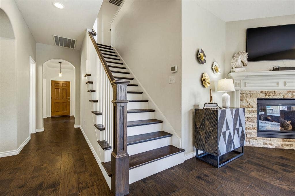 10138 Planters Row Drive, Frisco, TX 75033 Hardwood stair treads with crisp white risers lead upstairs to the game room, home office, and secondary bedrooms.