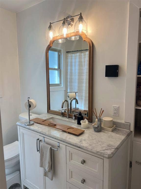 1200 Daisy Lane, Irving, TX 75061 White vanity with shaker-style cabinetry, a stone countertop, and a single basin undermount sink