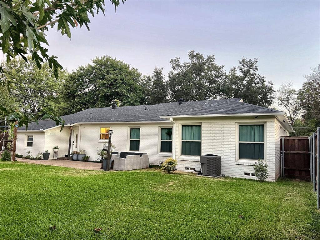 1200 Daisy Lane, Irving, TX 75061 Expansive green lawn with a paver patio and white brick exterior
