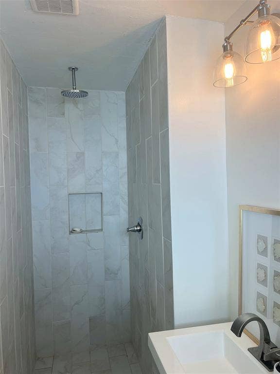 1200 Daisy Lane, Irving, TX 75061 Walk-in shower with vertical tile detailing, an integrated niche, and a ceiling-mounted rain showerhead