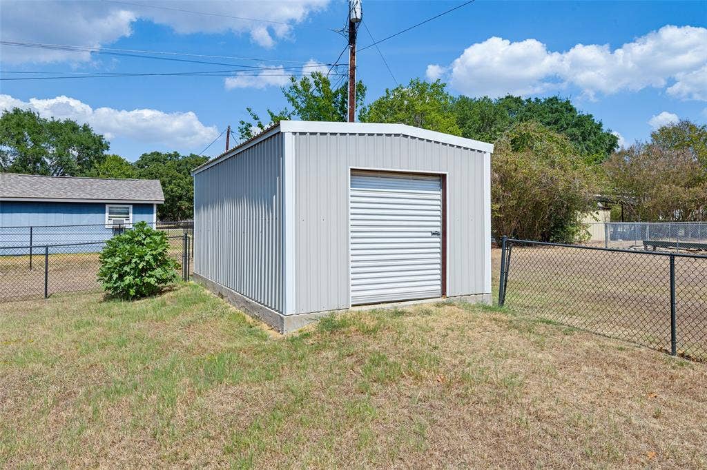 108 Rye Place, Gun Barrel City, TX 75156 Metal storage shed featuring a roll-up door