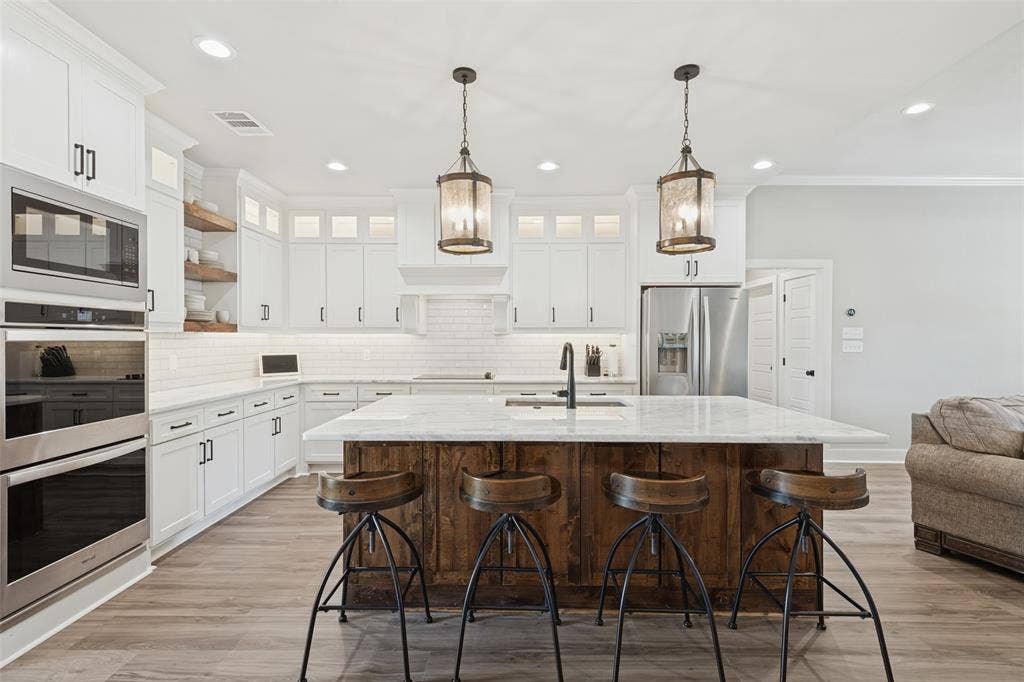 108 Rye Place, Gun Barrel City, TX 75156 Kitchen featuring a wood-finish island, white cabinetry, stainless steel appliances, and pendant lighting