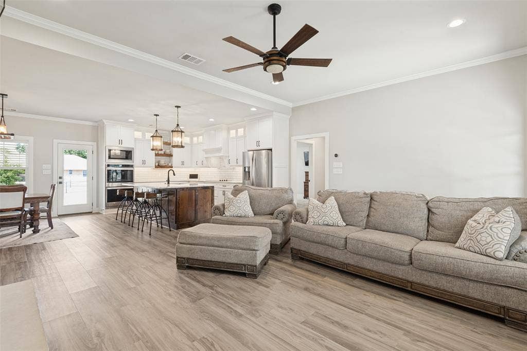 108 Rye Place, Gun Barrel City, TX 75156 Open-concept living space featuring wood-finish flooring, crown molding, and a ceiling fan