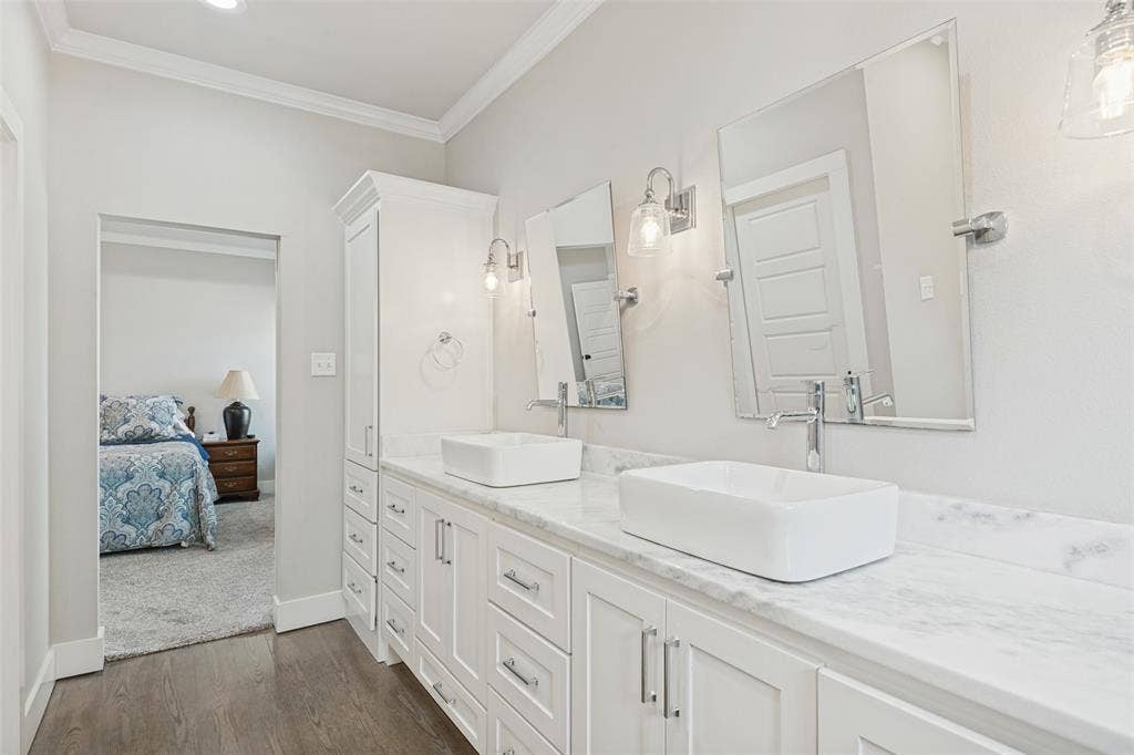 108 Rye Place, Gun Barrel City, TX 75156 Dual vessel sinks set on a stone countertop with white shaker cabinetry, individual wall-mounted mirrors, and chrome fixtures