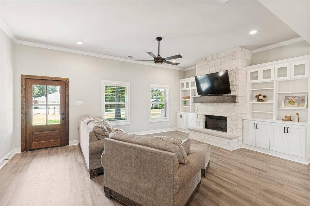 108 Rye Place, Gun Barrel City, TX 75156 Spacious room featuring wood-finish flooring, a stone-clad fireplace, and built-in cabinetry