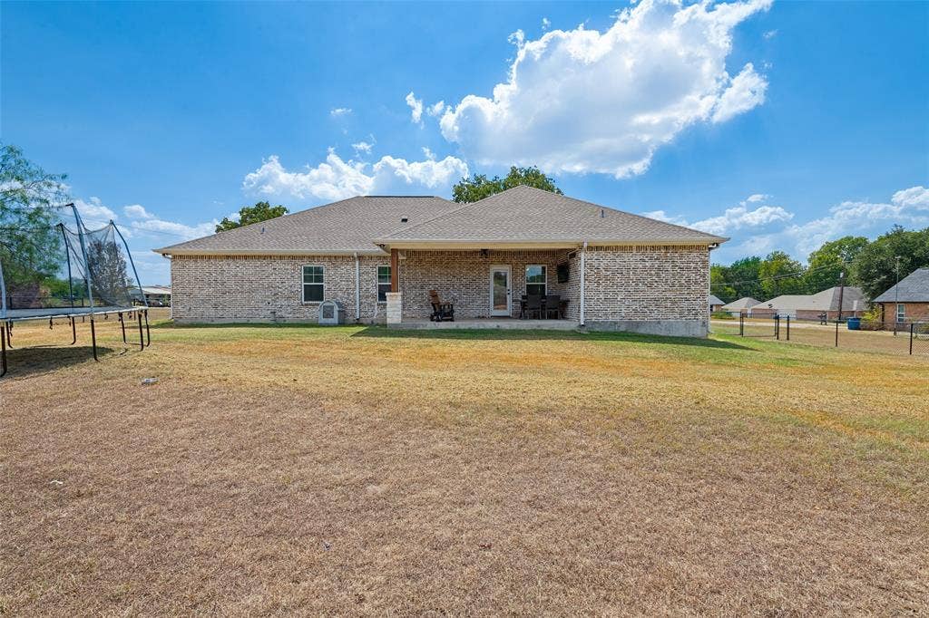 108 Rye Place, Gun Barrel City, TX 75156 Expansive backyard with a covered patio, brick exterior, and a shingle roof