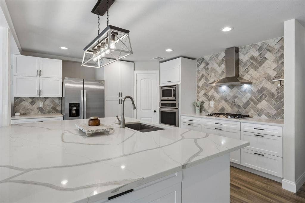 The quartz counters, stainless steal appliances, stunning lighting levels up this kitchen.