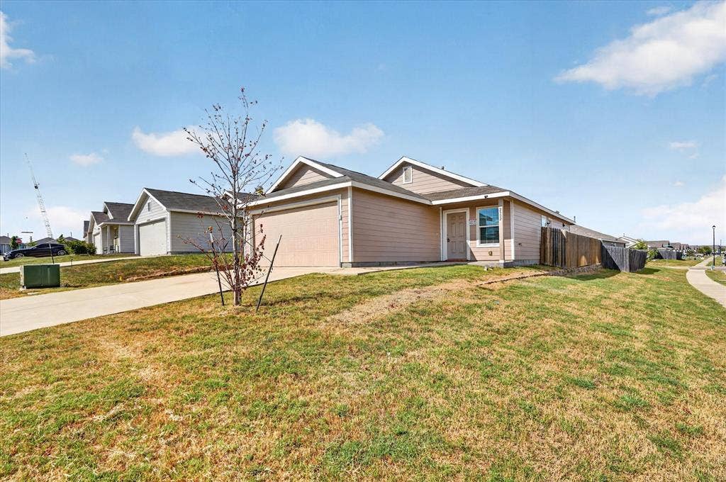 Single-story residence featuring a two-car garage, fenced backyard, and a paved driveway
