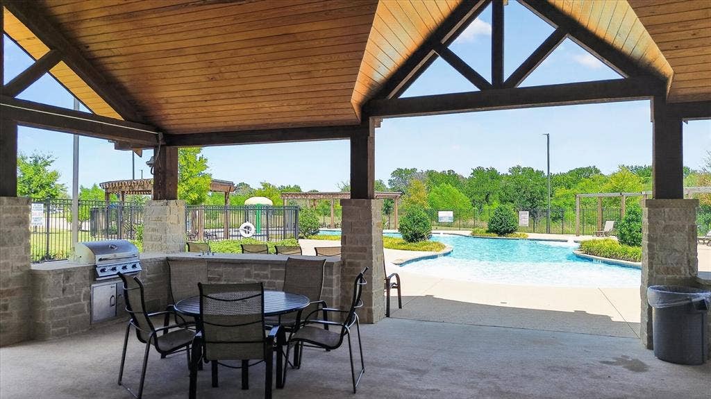 Covered outdoor patio with wood-finish ceiling and exposed beams