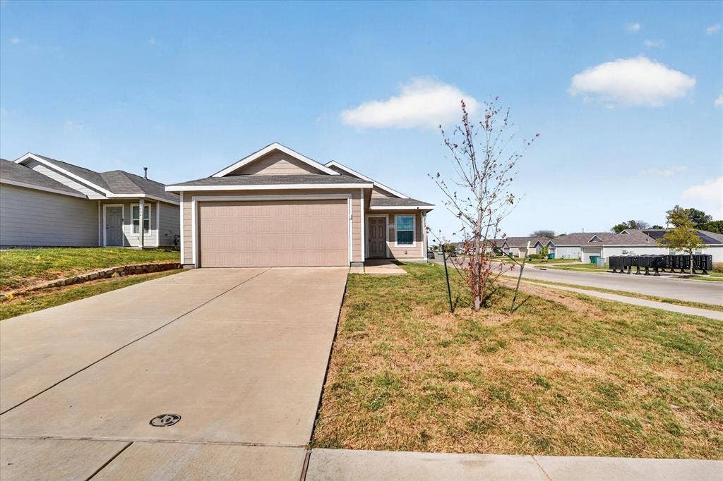 Single-story residence featuring a two-car garage, concrete driveway, and a front facade with neutral siding