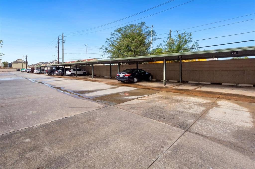 13026 Leader Street, #951, Houston, TX 77072 Covered parking spaces with concrete slab flooring and a low privacy wall