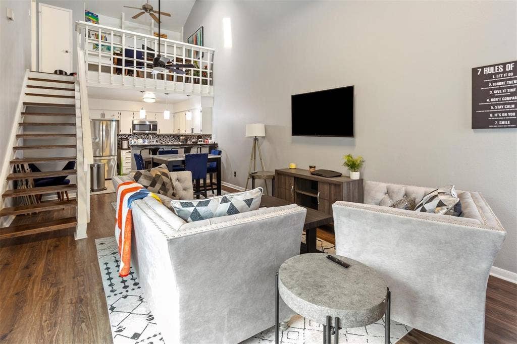13026 Leader Street, #951, Houston, TX 77072 Soaring vaulted ceiling, wood-finish flooring, open-tread staircase, and a lofted space with a spindle railing