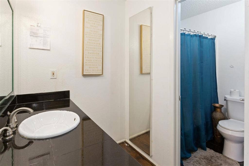 13026 Leader Street, #951, Houston, TX 77072 Bathroom 1 - Vanity with an oval undermount sink, brushed nickel faucet, and dark tile countertop