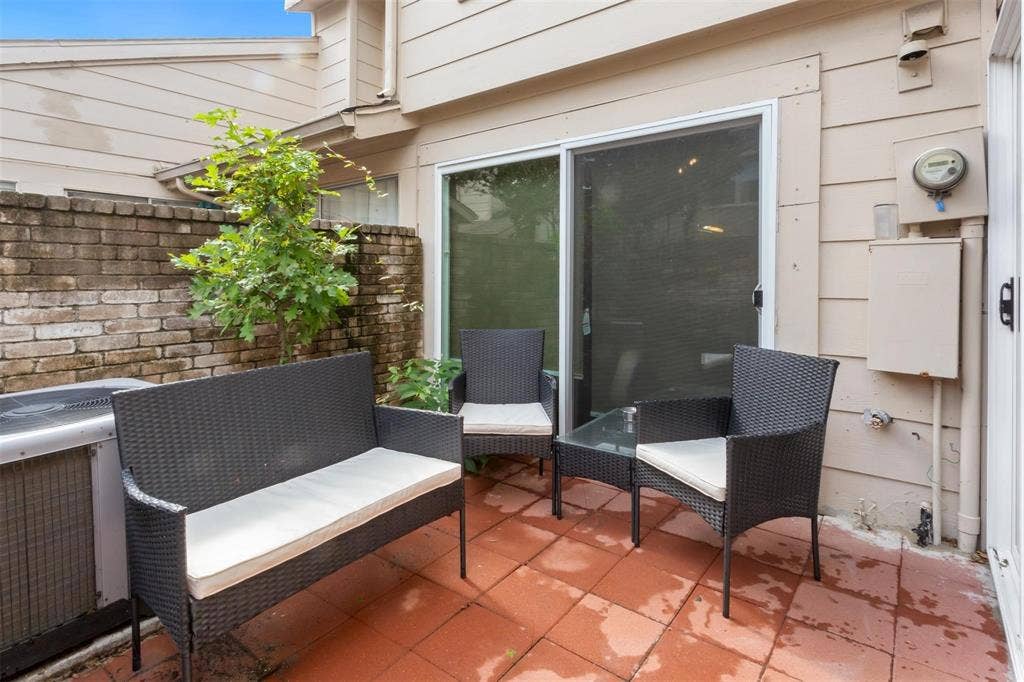 13026 Leader Street, #951, Houston, TX 77072 Private patio featuring terracotta-style pavers, a brick privacy wall, and sliding glass door access
