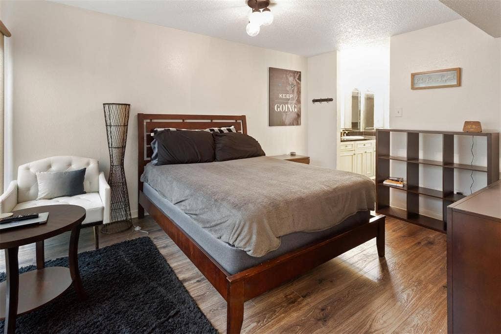 13026 Leader Street, #951, Houston, TX 77072 Bedroom 1 - Wood-finish flooring throughout, light-toned walls, and a built-in ceiling light fixture