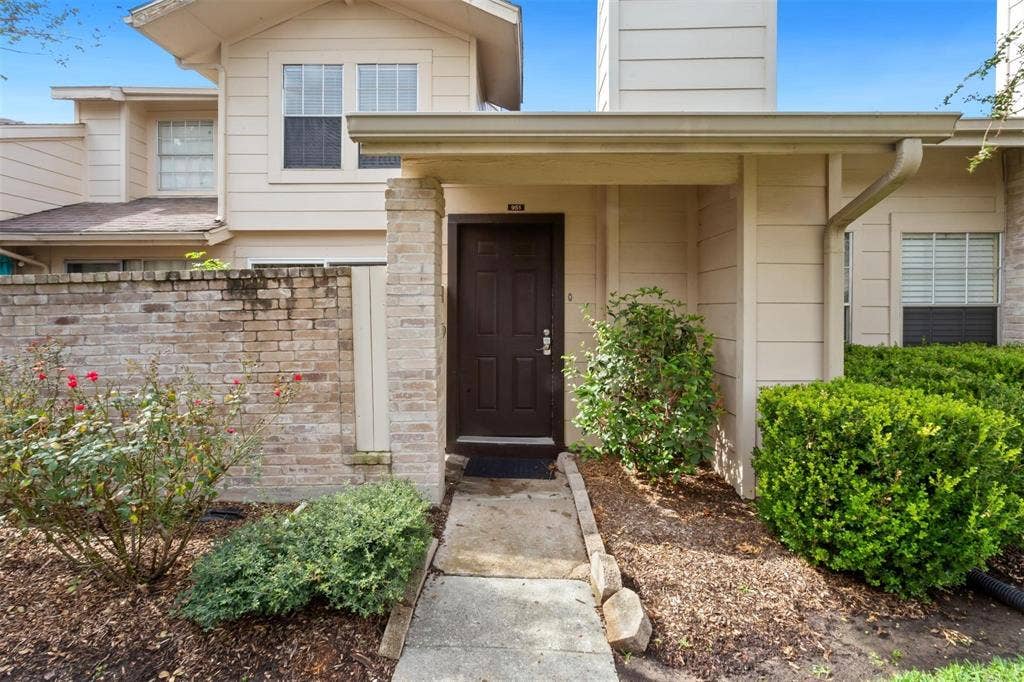 13026 Leader Street, #951, Houston, TX 77072 Entryway with a covered porch, brick column accents, and surrounding landscaping