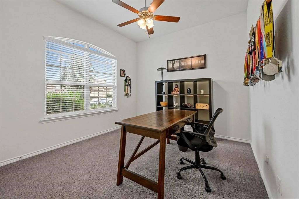 602 Brock Drive, Anna, TX 75409 Arched window with blinds, ceiling fan with light fixture, neutral carpet, and white walls